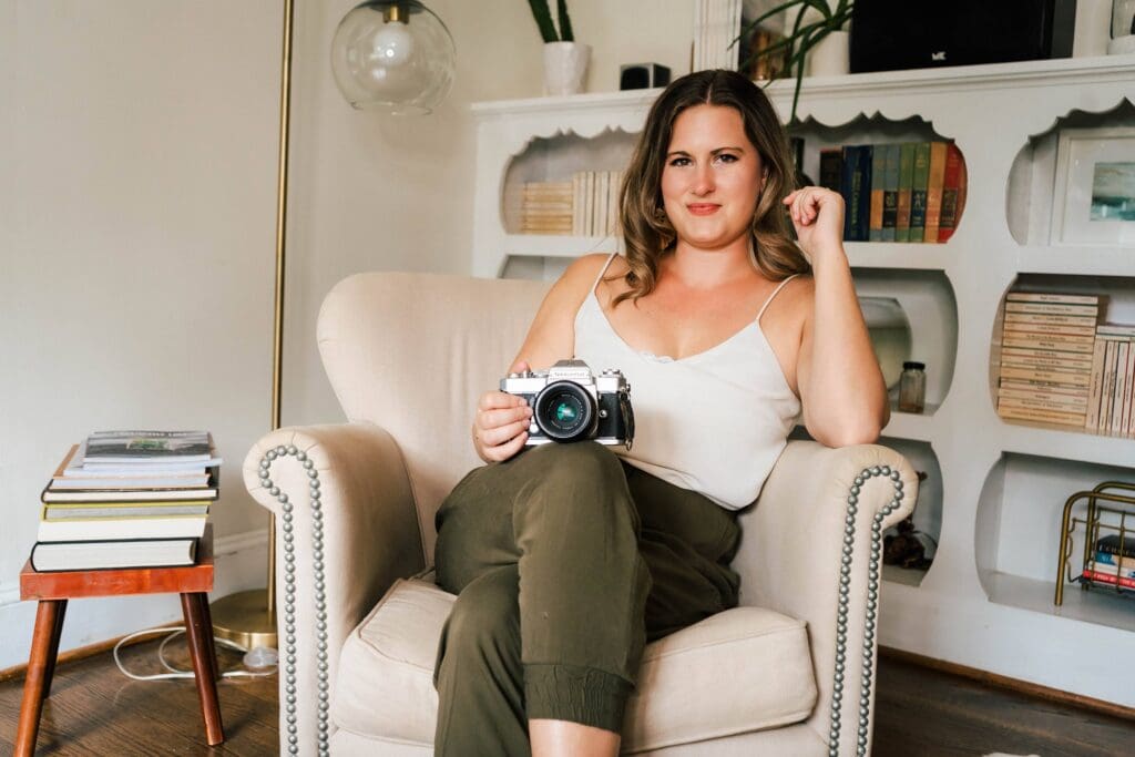 Owner of Thin spaces sitting on chair with film camera.