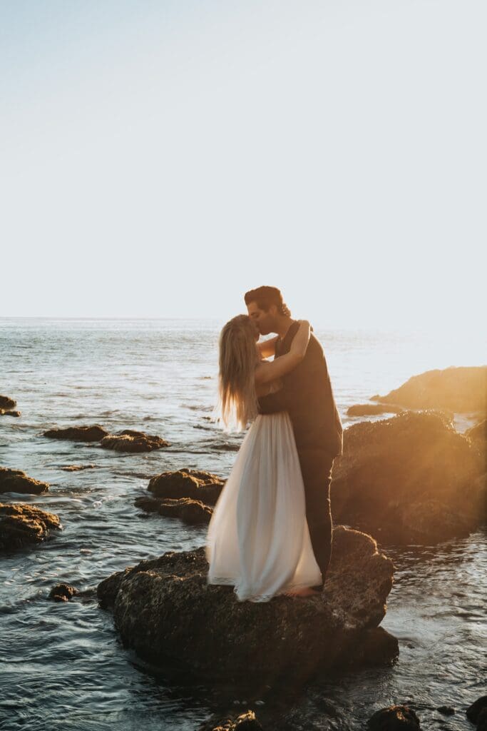 couple cudding on a rock on the bali coast