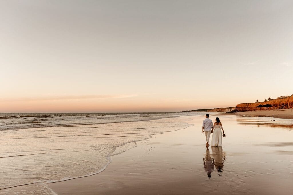married couple walking down beach at sunset in bali