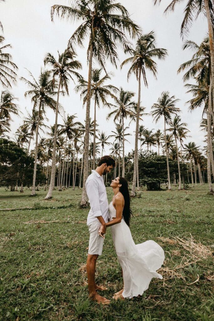 couple holding hands in a bali coconut tree forest