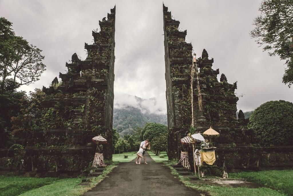 Couple on an adventure in bali. Kissing in between historic architecture