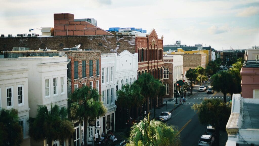 Historical buildings in downtown Charleston with traffic and street lights.