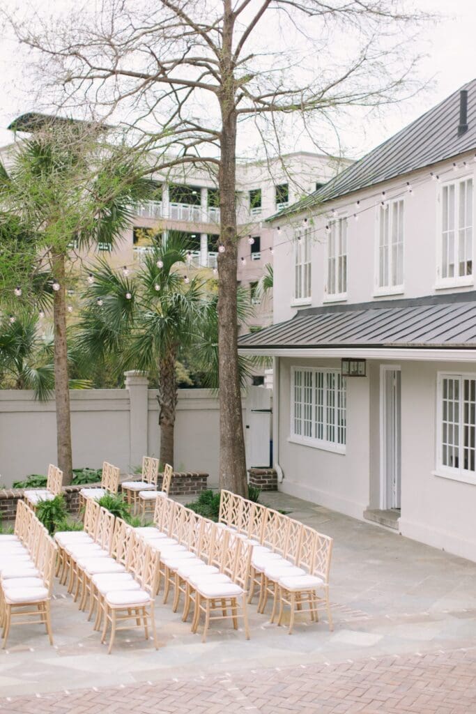 exterior view of gadsden house weddingt venue in charleston, south carolina with rows of chairs and string lights