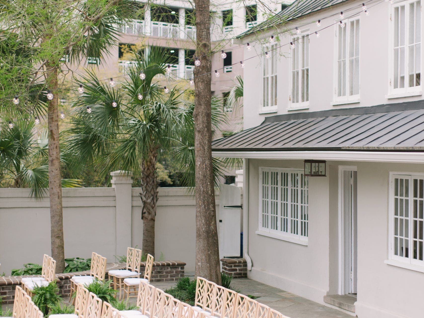 exterior view of gadsden house weddingt venue in charleston, south carolina with rows of chairs and string lights