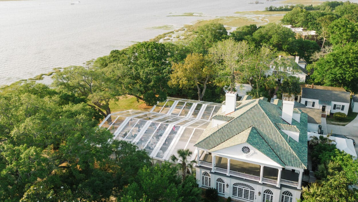 large white wedding venue surround by trees and the ocean