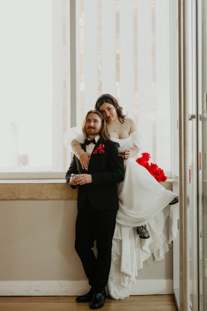 Couple just married at the Mint Museum with Charlotte skyline in background.
