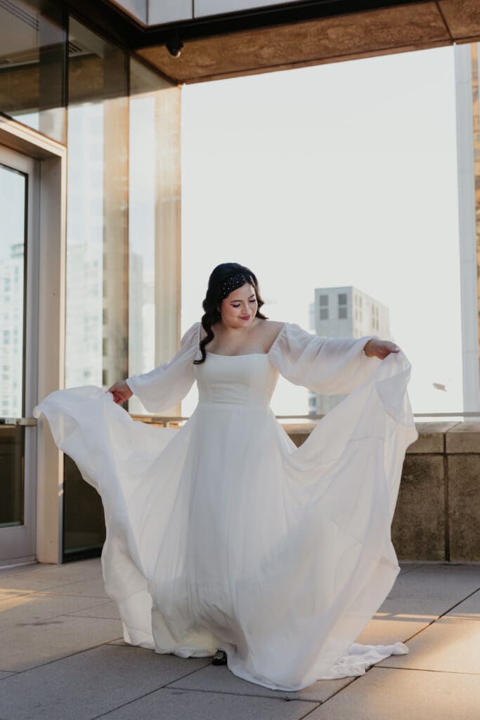 Bride admiring dress at her wedding at Mint Museum.