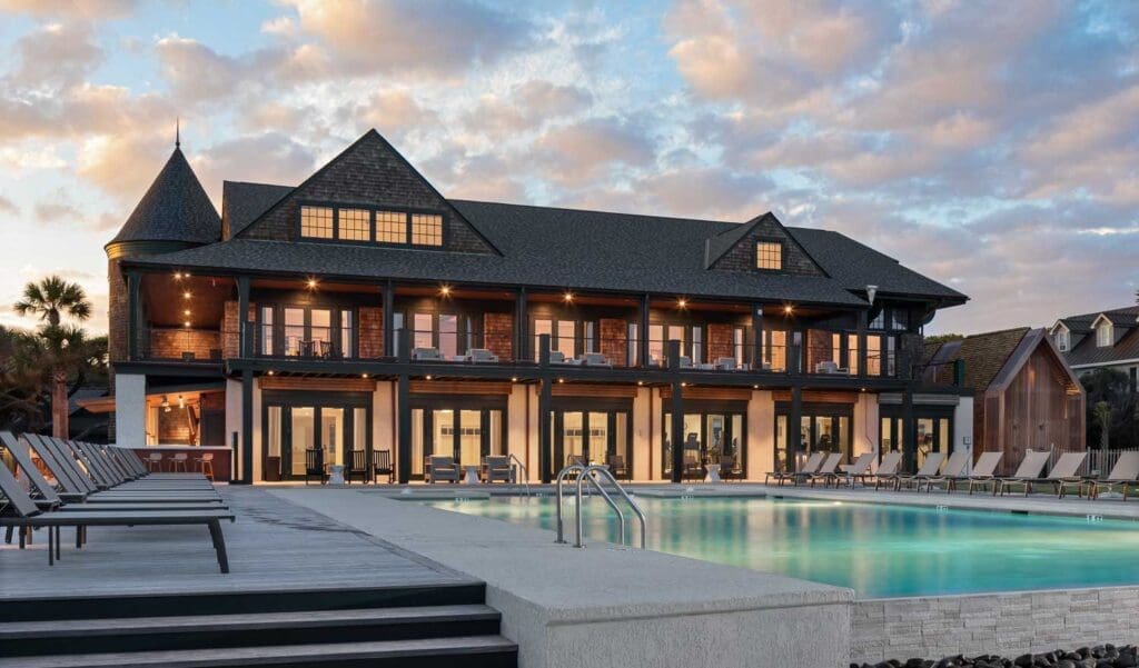 lit building at dusk with large swimming pool