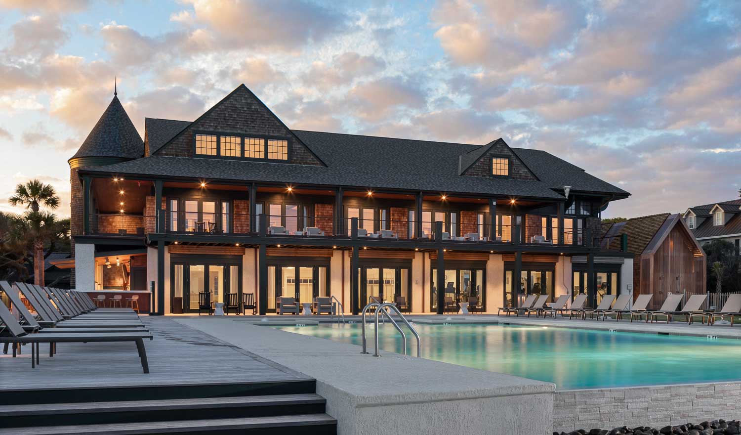lit building at dusk with large swimming pool