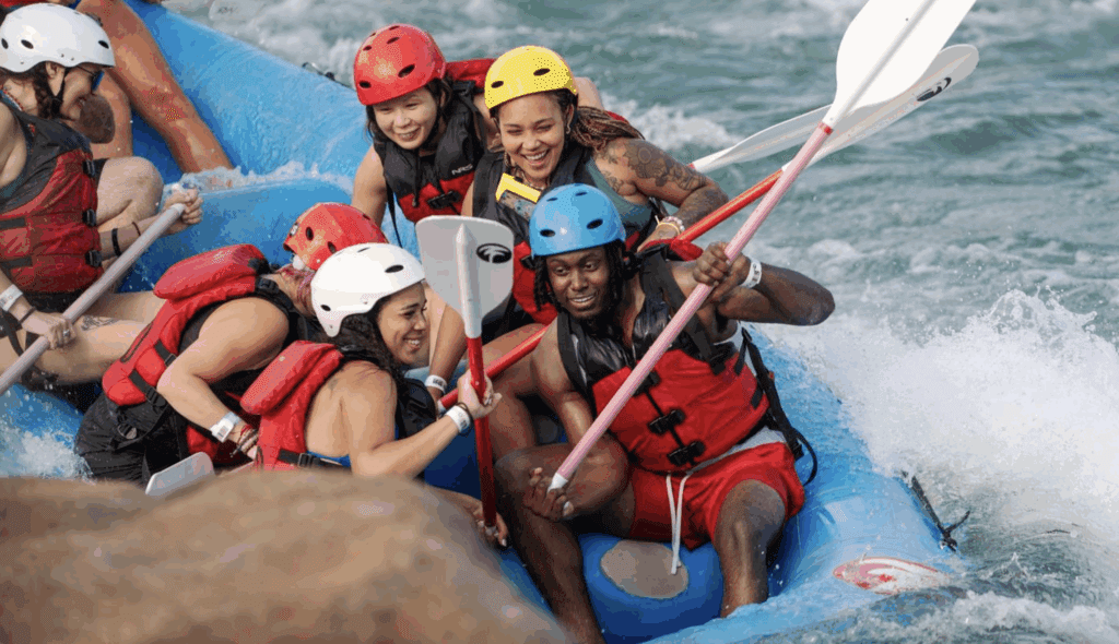 A group of people in a whitewater raft paddle is rough water.